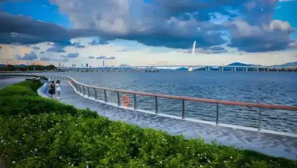 Shenzhen Bay Park coastal boardwalk sunset view across water to Hong Kong