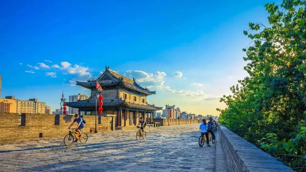 Cyclists riding along the top of Xi'an ancient City Wall at sunset