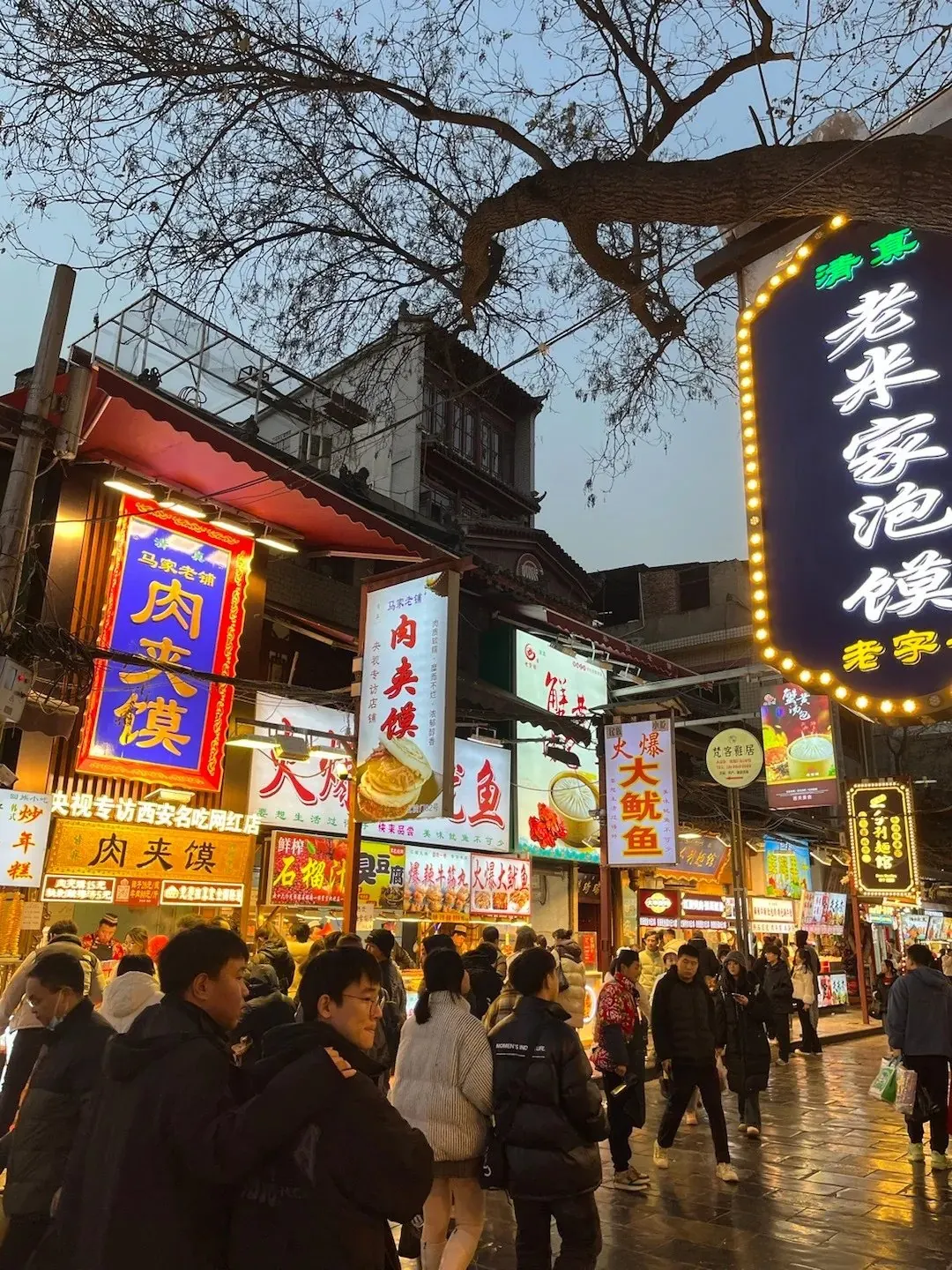 Muslim Quarter Huimin Street food stalls with Chinese lantern signs at dusk