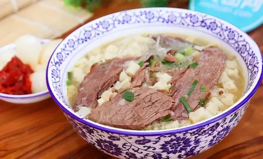 Yangrou Paomo lamb stew with torn flatbread in blue and white porcelain bowl